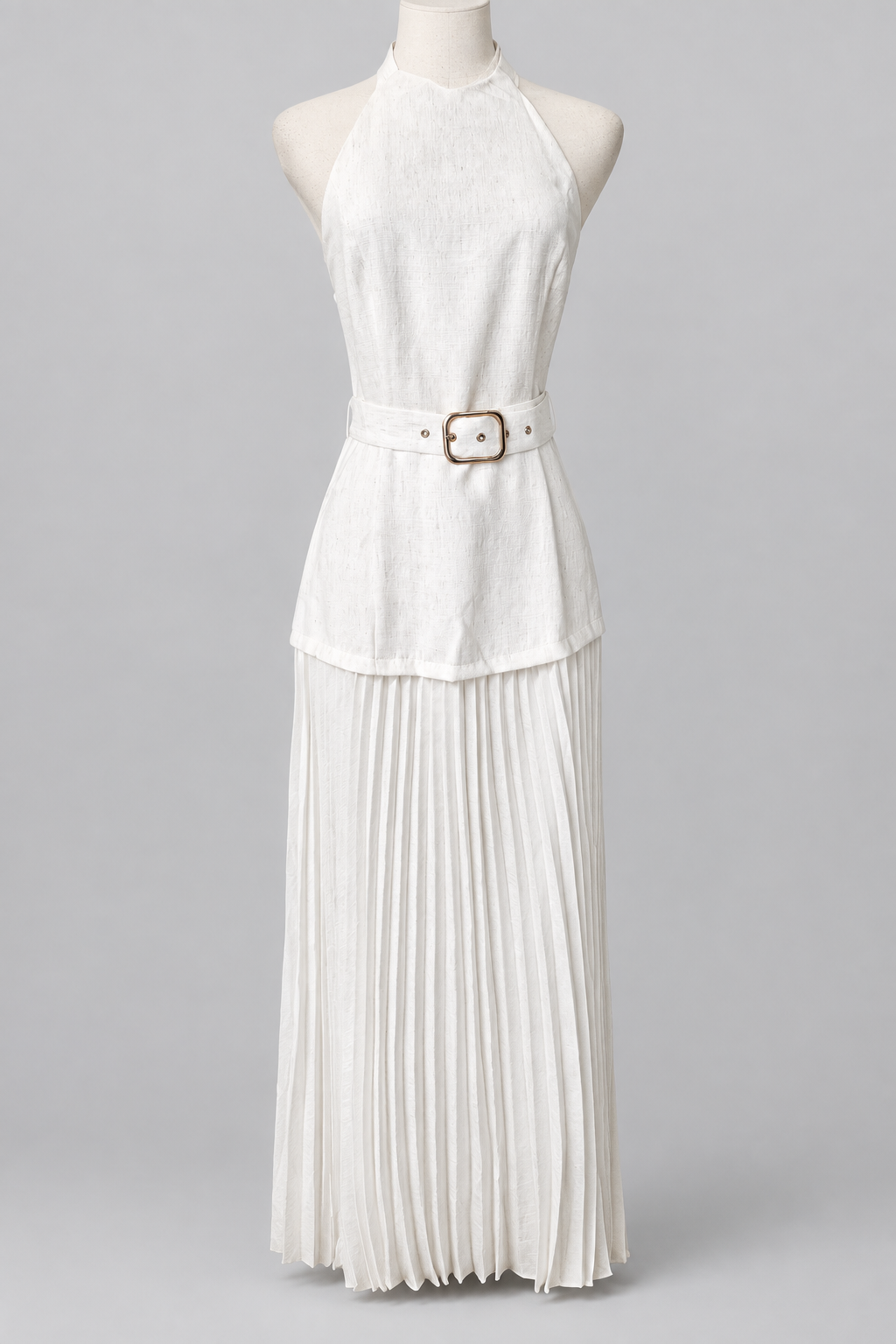White belted halter outfit with a pleated skirt on a plain light-gray background